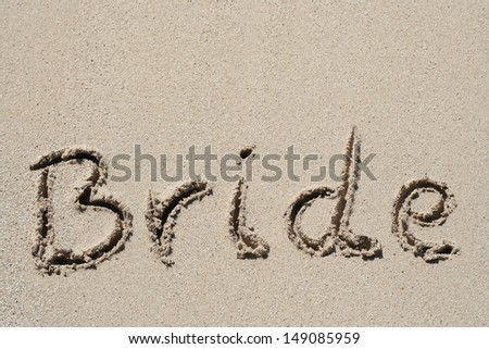 Concept or conceptual hand made or handwritten bride text in sand on a beach in an exotic island, metaphor to summer,ocean,sea,travel,vacation,tourism,tropical,happy,message,paradise wedding or couple