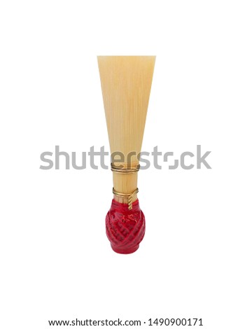 Double reed for bassoon rewound with red thread on a white background. Element for wind musical instruments. Royalty-Free Stock Photo #1490900171