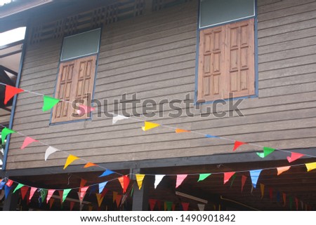 There're some colorful triangle rope flags hanging in a house. Some one is prepared and decorating the place for a party.