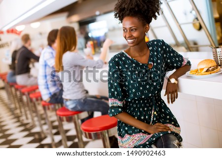 Pretty young african american woman sitting in the diner