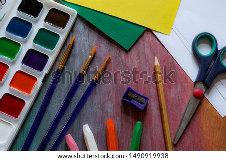 Stationery for children and creativity - watercolors, brushes, scissors, colored paper, pastel and sharpener.