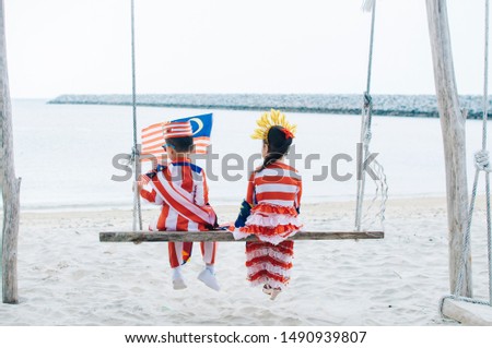 Boy and girl celebrating merdeka near the beach 