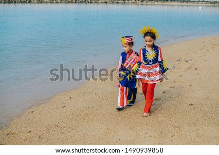 Boy and girl celebrating merdeka near the beach 