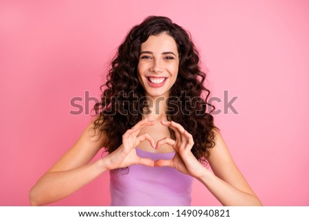Photo of cheerful cute charming attractive girl showing heart sign of love while isolated with pink background