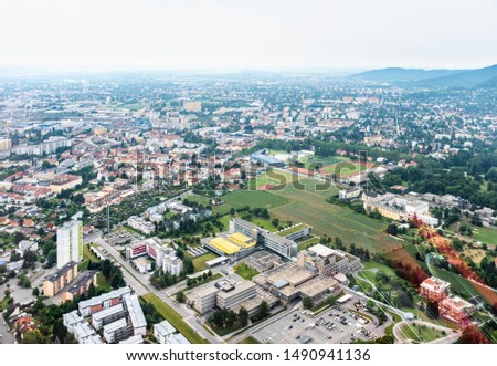 Aerial view of city Graz from helicopter drone with districts Gösting and the ukh hospital on a cloudy summer day in Austria, Europe