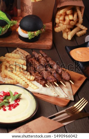 kabab meal with homas and konafa on wood table
