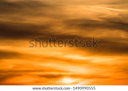 Huge sun behind stormy dramatic sky. background with yellow red and orange clouds. Sunset skyline. Storm on the beach