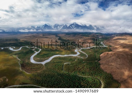Kurai steppe and Chuya river on North-Chui ridge background. Altai mountains, Russia. Aerial drone panoramic picture.