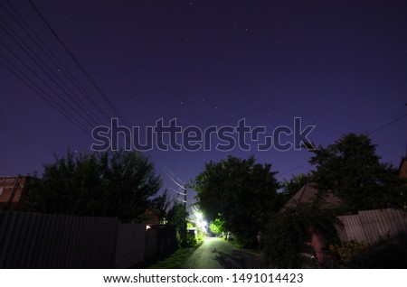 Beautiful night sky in a village with trees