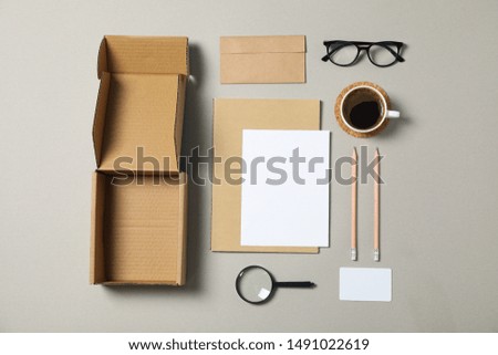Mockup. Corporate stationery, glasses and magnifier on grey background. Flat lay