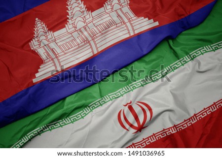 waving colorful flag of iran and national flag of cambodia. macro