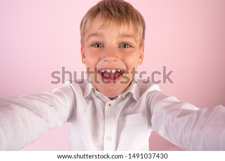Just me and no one else. Top view of handsome young boy making selfie and smiling while standing against pink background.