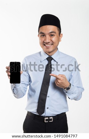 Asian male with songkok showing phone