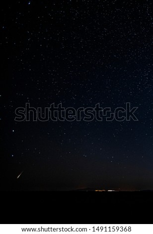 Falling star on a starry night sky in summer. Away from city lights. 