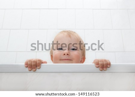 Picture of a little boy looking out of bathtubs 