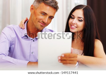 Young couple with electronic tablet at home
