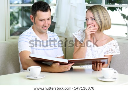 Beautiful young romantic  couple with photo, at home