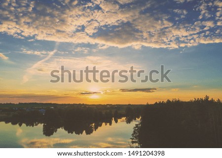 Magical sunrise over lake with beautiful reflection on water. Serene lake in early morning. Nature landscape. Aerial view