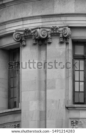 Elements of architectural decorations of buildings, columns and capitals, gypsum moldings, wall textures and patterns. On the streets in Barcelona, public places. Black and white retro style photo.