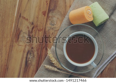 Coffee and bread placed on brown wood floors.