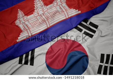 waving colorful flag of south korea and national flag of cambodia. macro