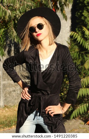 attractive woman in black trench suede coat, wool hat and round glasses, artsy bohemian style, fashion blogger outfit