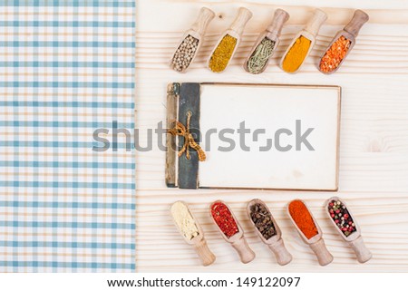 Recipe cook book, spices, tablecloth on wood background