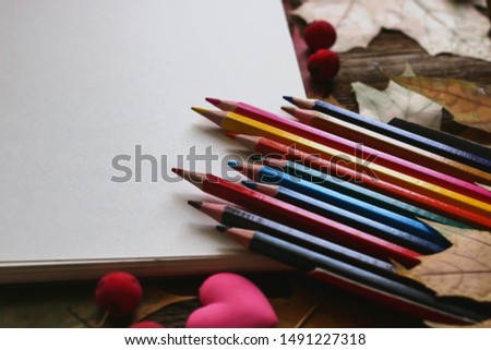 notebook and pencils. a cup of coffee. stationery on a background of autumn leaves.