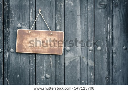 Old sign board blank hanging on vintage black wood planks background