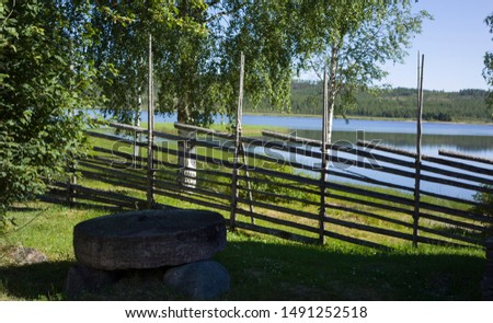 A wooden fence, old style in Sweden with a lake in the background.