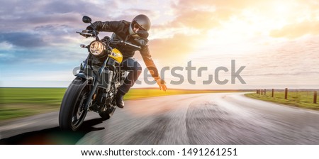 man on a motorbike on the road riding. having fun driving the empty road on a motorcycle tour journey. copyspace for your individual text. Royalty-Free Stock Photo #1491261251