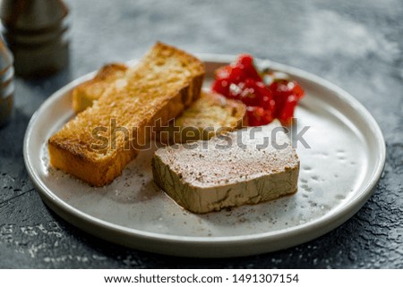 The chicken liver pate with bread and jam on dark grey concrete table