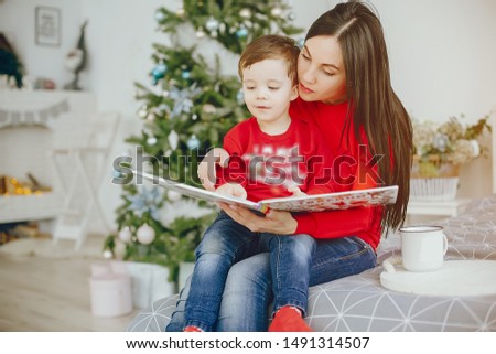 Cute family have fun in decorating room. Beautiful mother with little son. Family in a red sweaters