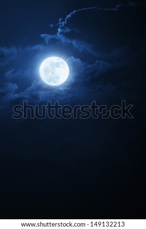 This dramatic photo illustration of a nighttime scene with brightly lit clouds and large, full, Blue Moon would make a great background for many uses.