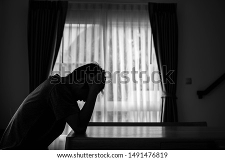 Alone man silhouette sitting on the table closed with curtains in home, Depression and anxiety disorder concept. Royalty-Free Stock Photo #1491476819