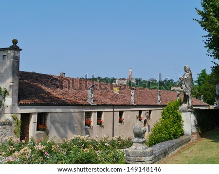 The outbuildings with statues on the roof along the entranceway to the villa Rotonda near Vicenza in Italy