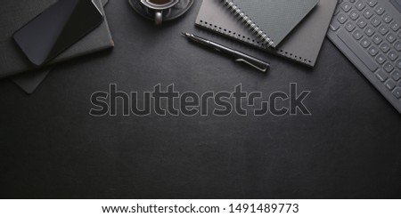 Top view of dark stylish workplace with smartphone and office supplies on black leather table background  Royalty-Free Stock Photo #1491489773