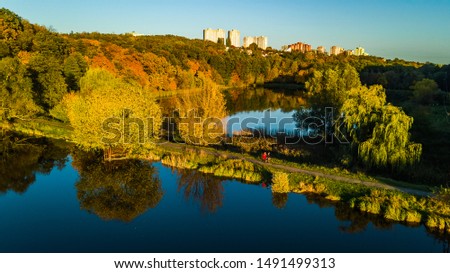 Golden autumn background, aerial drone view of forest with yellow trees and beautiful lake landscape from above, Kiev, Goloseevo forest, Ukraine