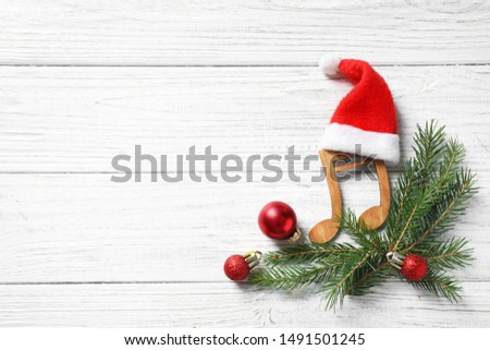 Flat lay composition with note on white wooden background, space for text. Christmas music concept