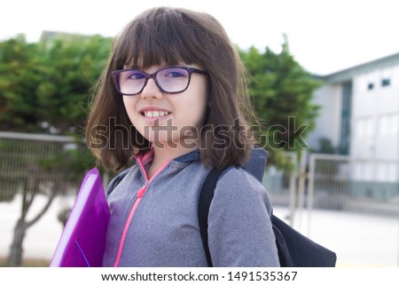 student in front of the school or campus