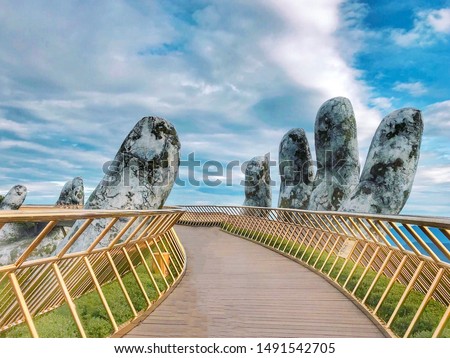 The Golden Bridge is lifted by two giant hands in the tourist resort on Ba Na Hill in Danang, Vietnam. Ba Na Hill is a favorite destination for tourists. Royalty-Free Stock Photo #1491542705