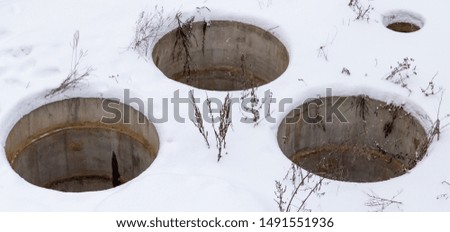 Sewer manholes in the snow in winter.