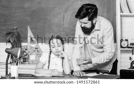 let me help you. bearded man teacher with small girl in classroom. daughter study with father. Teachers day. education child development. back to school. knowledge day. Home schooling.