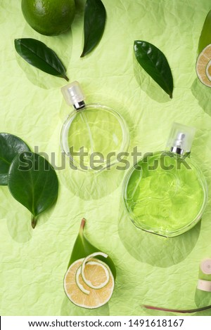  perfume bottle around ingredients  on green background. flat lay. 