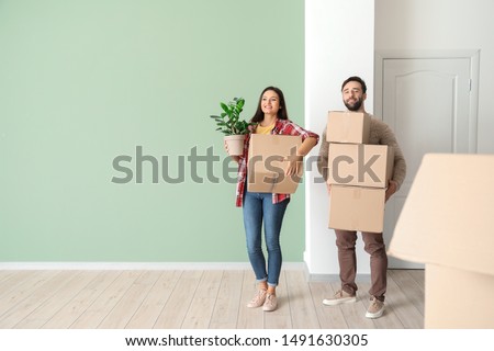 Happy young couple with cardboard boxes in their new house Royalty-Free Stock Photo #1491630305