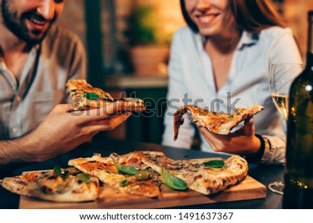 close up of people eating pizza