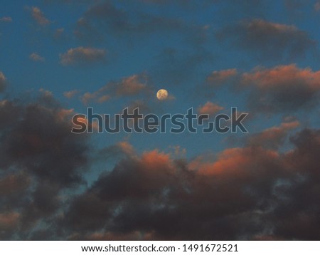 SAO PAULO, BRAZIL - Waxing Crescent Moon, framed by orange shaded clouds, observed during the golden hour in the southern hemisphere.