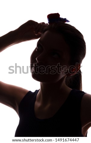 Young woman in hat looking up - vertical silhouette of a front view