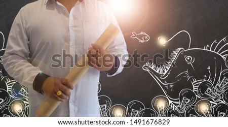Businessman hold notebook with growth graph chart on blackboard with strategy concept design ,white chalk to write business plan on black board background,with copy space for text.Chalk drawing idea