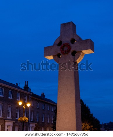 Night-time photography in city streets with old buildings in background, bright street lights.  Town roads at night, ghostly vibe. War monument.